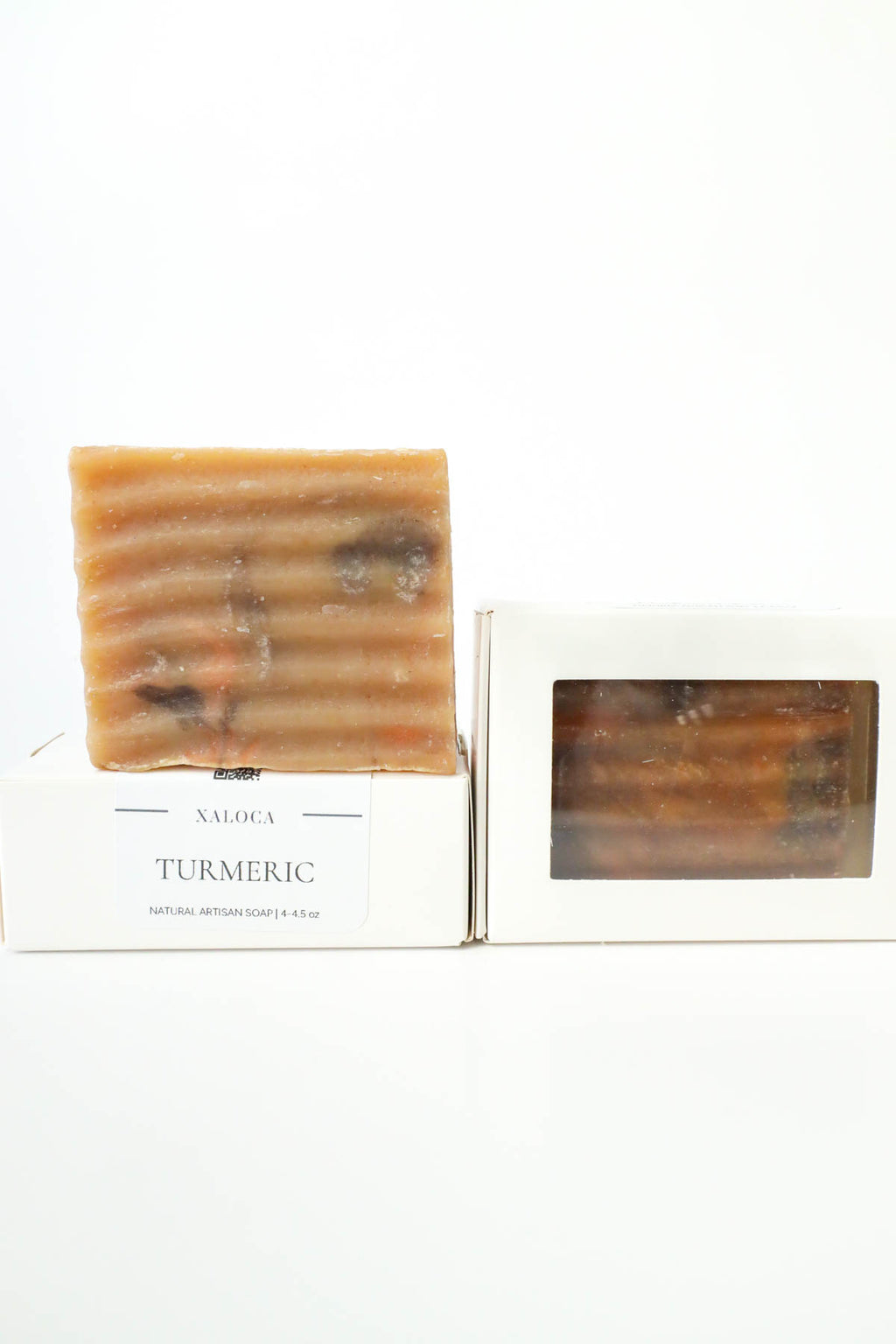 Bar of turmeric soap on a white background with a branded box.