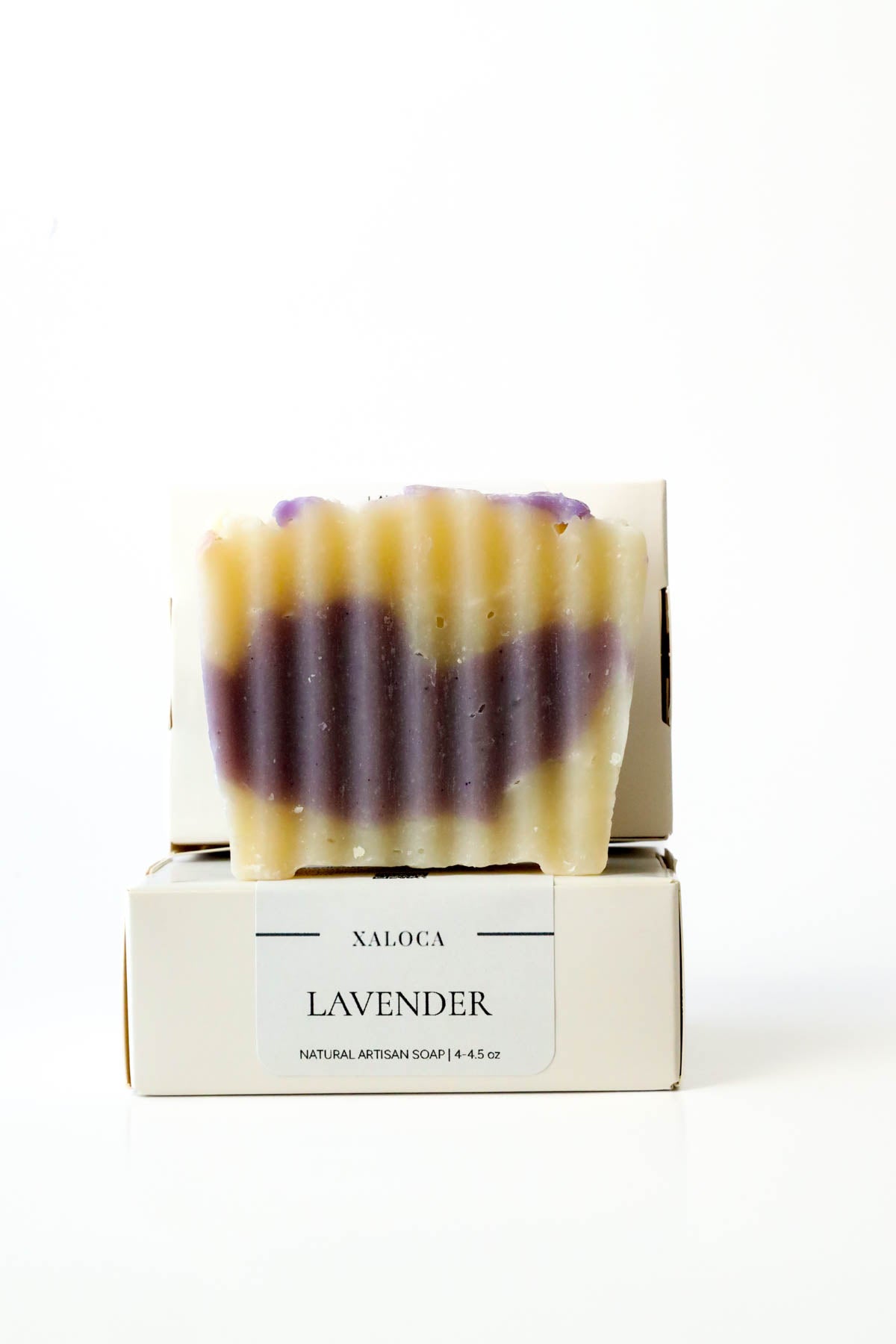 Lavender soap bar with striped design on a white background