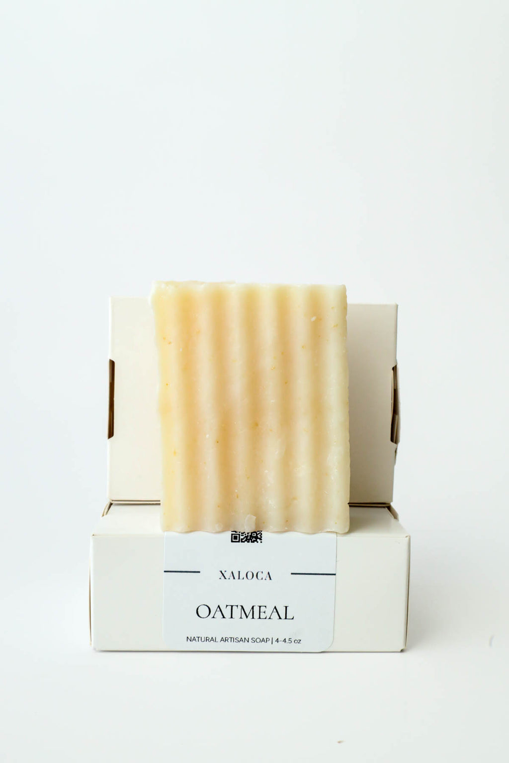 Bar of oatmeal soap in a white box on a white background