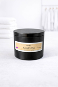 Black candle jar labeled 'Laundry Day' on a white background