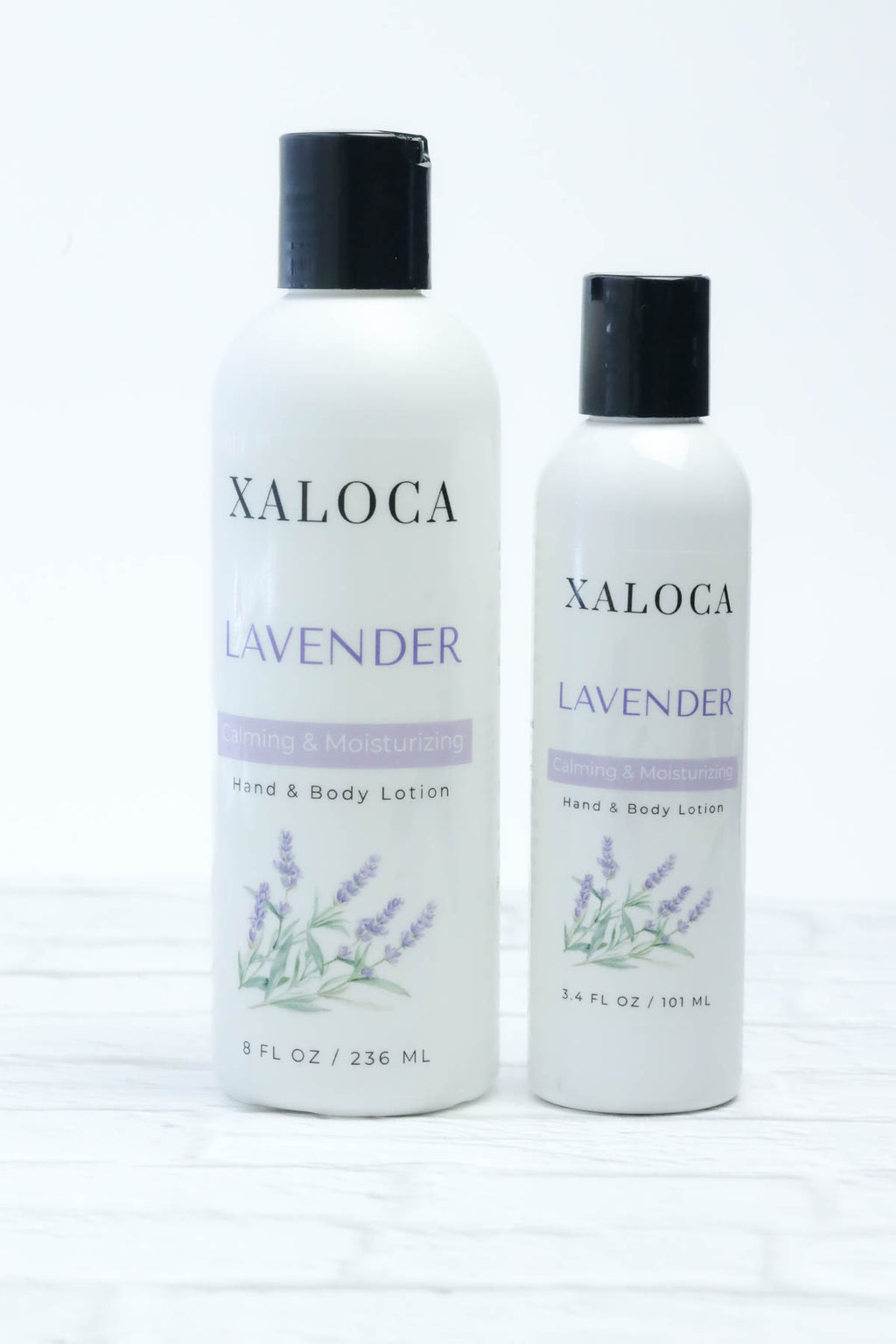 Two bottles of Xaloca Lavender hand and body lotion on a white background