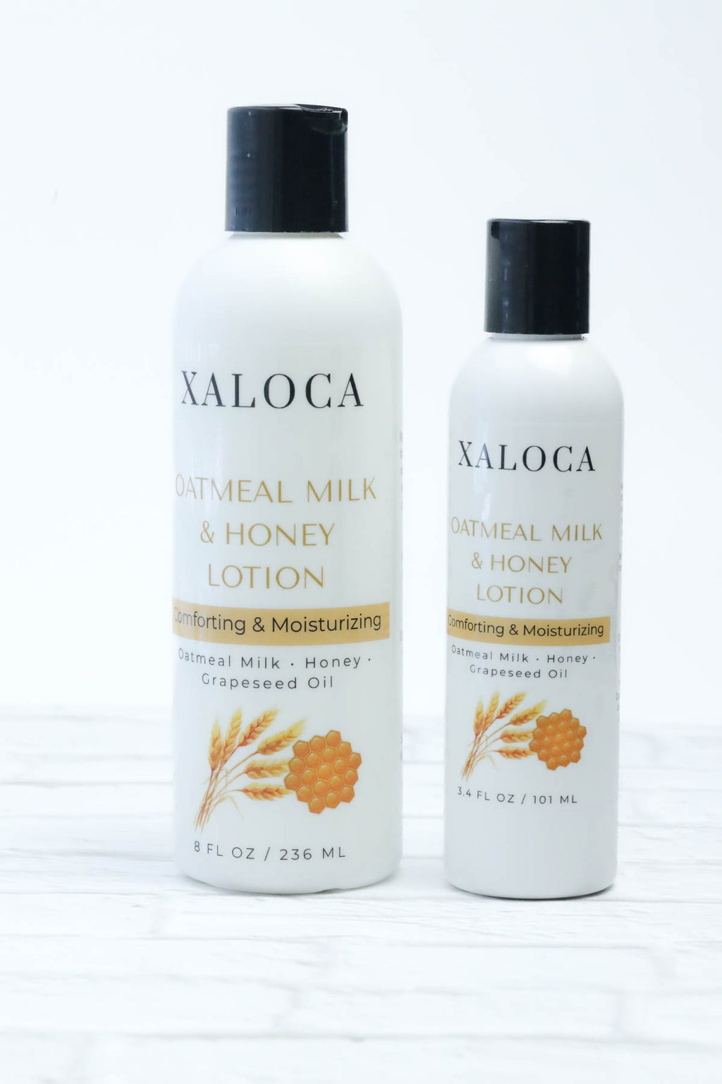 Two bottles of Xaloca Oatmeal Milk & Honey Lotion on a white background