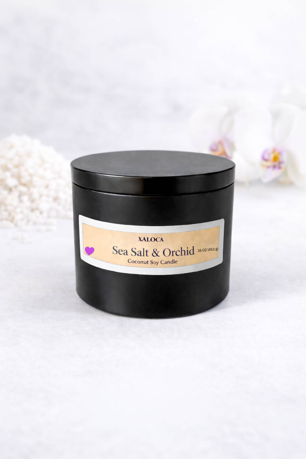 Black candle jar with 'Sea Salt & Orchid' label on a white background