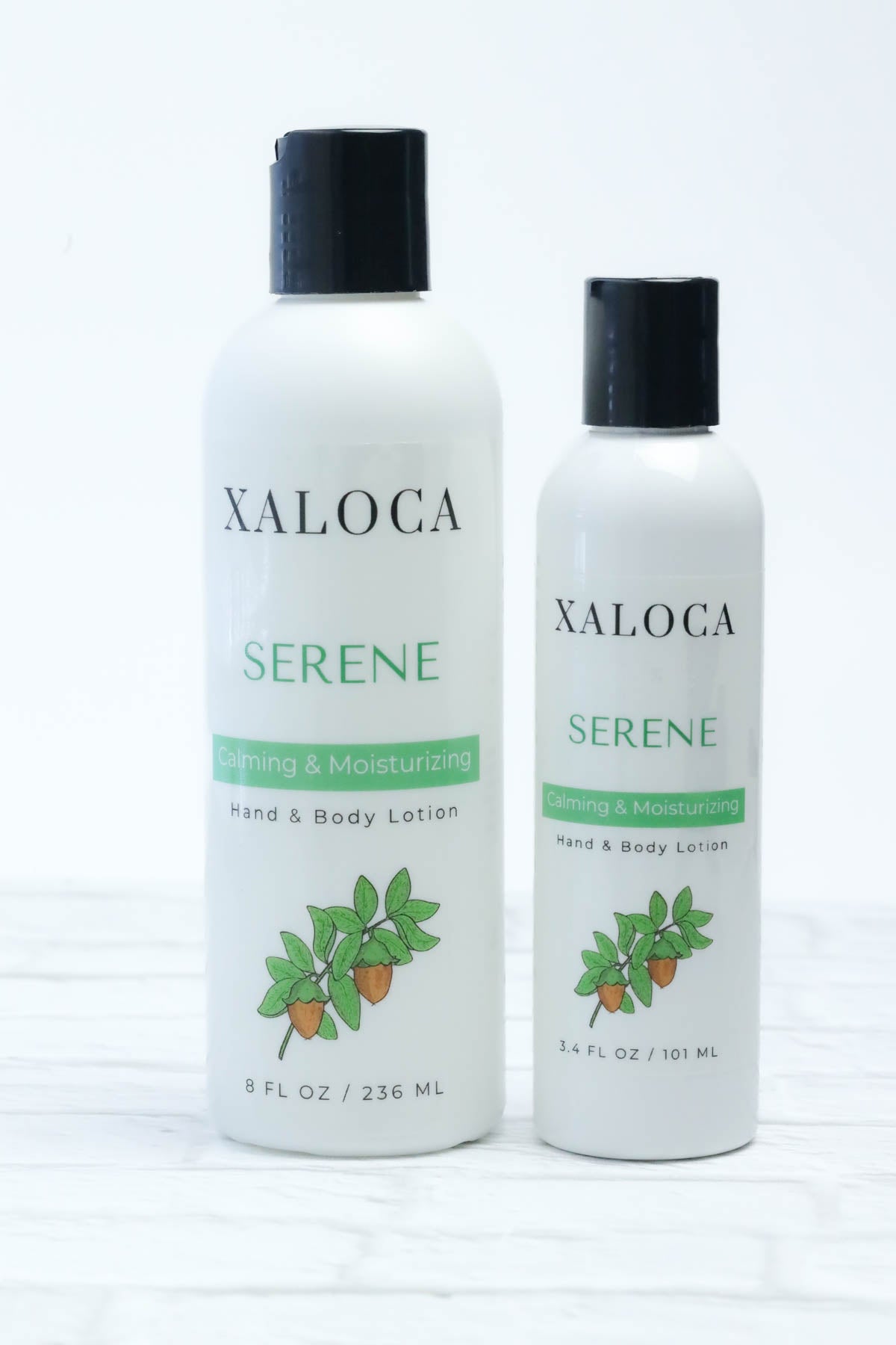 Two bottles of Xaloca Serene hand and body lotion on a white background